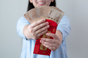 Asian women are glad to receive a lot of extra money from red envelopes.