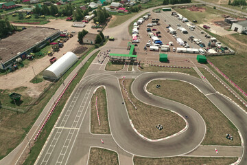 Aerial drone view of curving road for kart racing. Photo of karting race track, contemporary circuit, top view - obrazy, fototapety, plakaty