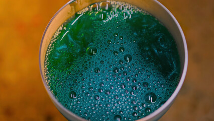Close-up of beautiful sparkling drink in transparent glass. Stock footage. Luxurious colored drink...