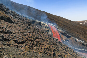Lava flow  Etna volcano eruption with smoke and gas 