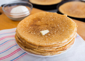 process of baking pancakes in pans on kitchen stove. stack of hot pancakes