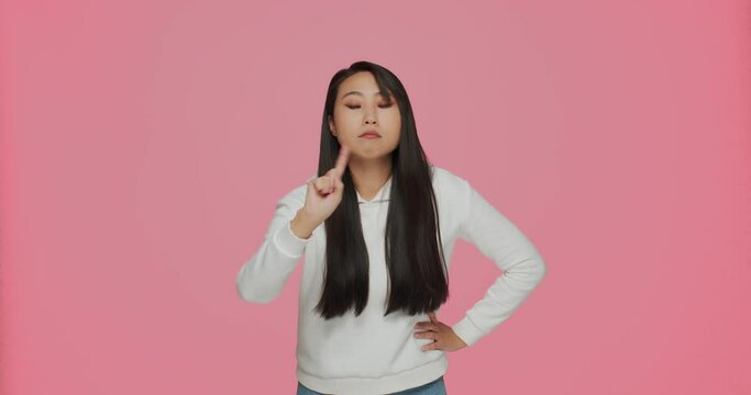 Asian serious angry young girl say no, make warning gesture by raised index fingers, scolding, rebuking, prohibiting