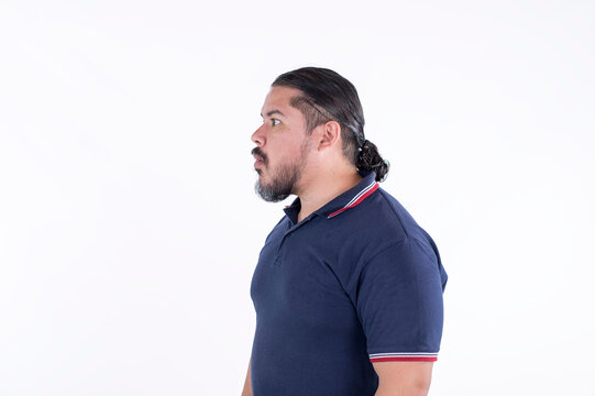 Side view of a man in his late 30s with a ponytail ogling at someone or dumbfounded in shock.