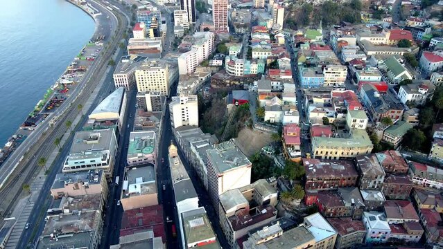 Aerial dolly out rising over Valparaiso hillside buildings and funicular in Cerro Concepcion near the sea, Chile