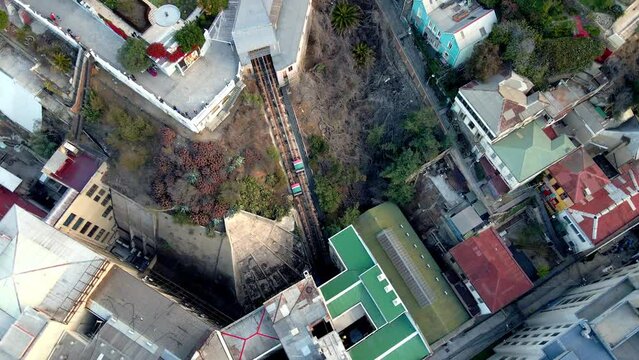 Aerial top down spinning of two carriages going up and down in El Peral funicular, Cerro Alegre, Valparaiso, Chile