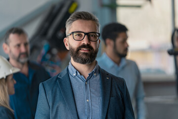 Portrait of male chief engineer in modern industrial factory looking at camera.