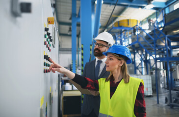 Engineering manager and mechanic worker doing routine check up in industrial factory