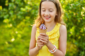 Happy girl with braces eating italian ice cream cone smiling while resting in park on summer day