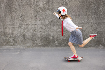 Funny businesswoman riding skateboard outdoor