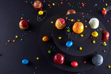Modern hand painted with different colors  chocolate candy like a space and planets. Product...