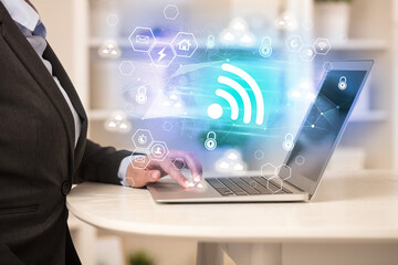 Hands working on laptop with digital icons