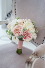 beautiful bridal bouquet with roses, peonies and feathers. pink ribbon. wedding details