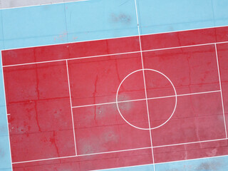 zenithal drone view of the center of a red tennis court