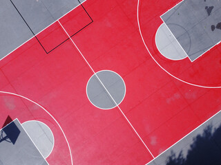 top drone view of the center of a red basketball court