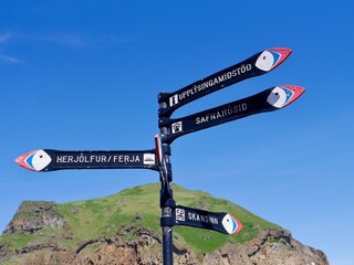 Street signs in the form of puffins on Westman Island, Heimaey, Heimatklettur in the background....