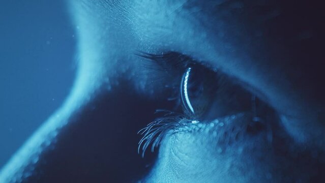 Young girl eye closeup loop. Blue light. Profile. Slow motion. Macro. 