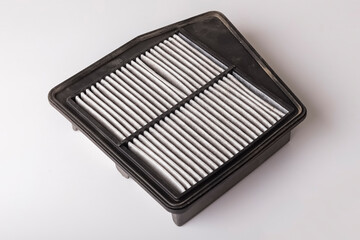 Worn out car air filter on a white background. Protection against dirt and dust. Car spare parts concept