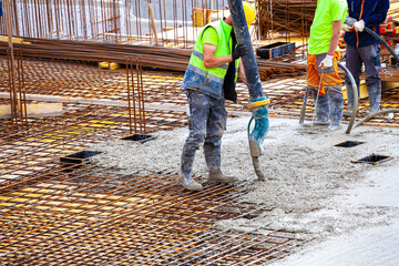 workers pour concrete on the construction site