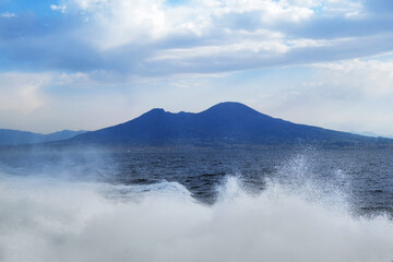 Blue landscape background. Vesuvius mount and waves of the Tyrrhenian Sea seen from a ferryboat, Naples, Italy
