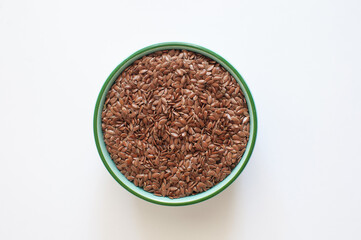 Top view of organic and healthy raw flaxseeds or linseeds in green bowl. Natural, proper nutrition, superfood isolated on white background.