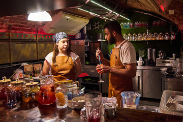 Male and female bartenders are making cocktails