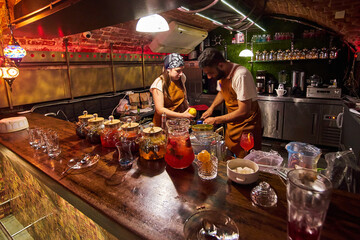 Male and female bartenders are making cocktails