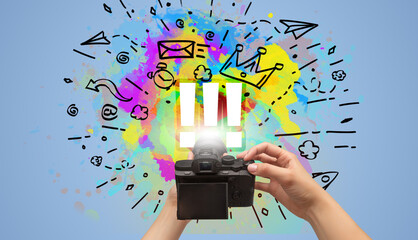 Close-up of a hand holding digital camera with abstract drawing concept