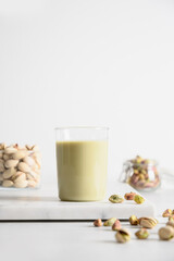 Nutty vegan Pistachio milk on white background. Vegan plant based milk. Vertical format.