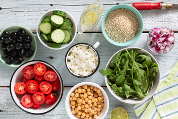ingredients of vegetable salad with quinoa, cottage cheese and olive oil. The process of preparing a delicious vegetarian fresh vegetable salad with quinoa and cottage cheese