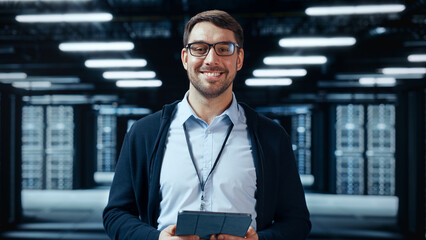 Portrait of a Bearded Handsome Caucasian IT Specialist in Glasses Standing with Tablet and Posing...