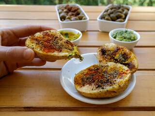 Spicy baked potatoes with sauces for lunch at garden table. Vegan food concept