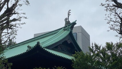 Fototapeta premium The contrast of new modern city office buildings in the back, with Japanese traditional architectural heritage built in 1935, “Yushima Seido” at central Tokyo Japan, shot taken on rainy season year 20