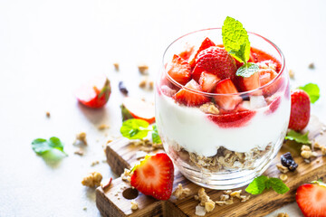 Parfait with cream or yogurt, jam and fresh berries in the glass jar. Healthy summer dessert.