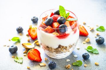 Parfait with cream or yogurt, jam and fresh berries in the glass jar.