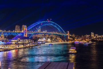 Colourful Light show at night on Sydney Harbour NSW Australia. The bridge illuminated with lasers and neon coloured lights 