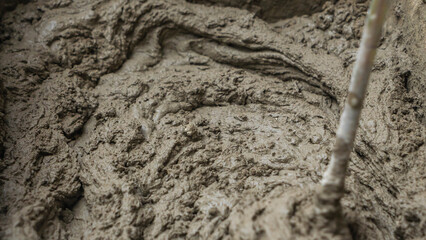 Mixing tile adhesive or cement with a power drill for repair works on construction site. Waiting to be mixed with cement.