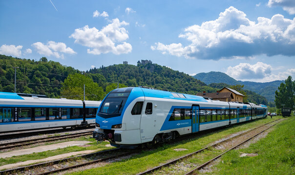 Celje, Slovenia - May 13, 2022: A picture of a train from Slovenian Railways stationed in Celje overlooked by the Celje Castle.