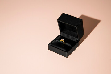 Golden engagement ring in black box with jewel. Marriage Proposal ring with a single brilliant.