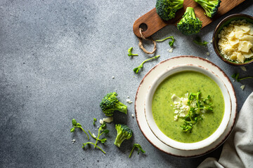 Broccoli cream soup with parmesan and microgreen. Healthy green soup, vegan dish. Top view at stone table.