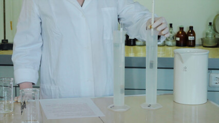 Close-up partial view of scientists making experiment with reagent and flasks. close up of...