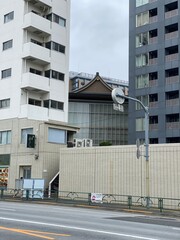 Traditional temple house rooftop peeking between the new modern buildings, cityscape Tokyo year 2022 June 14th