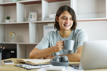 Distance education concept, Teen boy drinking coffee and studying lesson class online at home