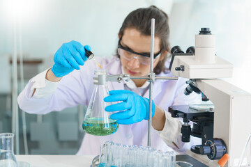 Fototapeta premium Laboratory research concept, Scientist drop of solution into beaker for research of vaccine