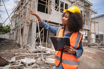 Mechanical engineer African American woman finger point on construction home building site	