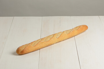Barra de pan baguette en la mesa blanca