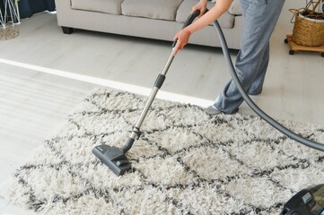 Cleaning concept. woman cleaning carpet with vacuum cleaner. - obrazy, fototapety, plakaty