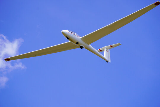 White glider with blue cloudless sky in the background. Aircraft for gliding.