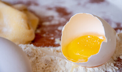 SESSION: PASTA PREPARATION - healthy broken eggs with flour next to it on wooden table