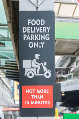 "Food delivery parking only" sign is seen at a designated parking space outside a restaurant.