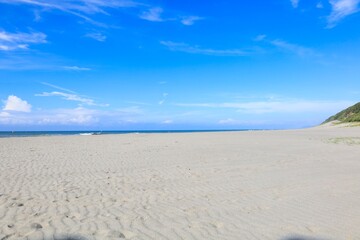 早朝の青い空が広がる太平洋の波と砂浜